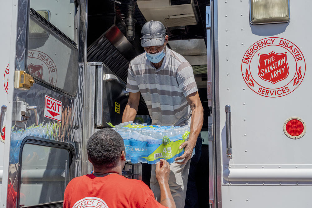 Booker Ellis, an employee at the Mississippi Industries for the Blind and Walter Houston, a Salvation Army employee, unload water donated by the Salvation Army in Jackson.