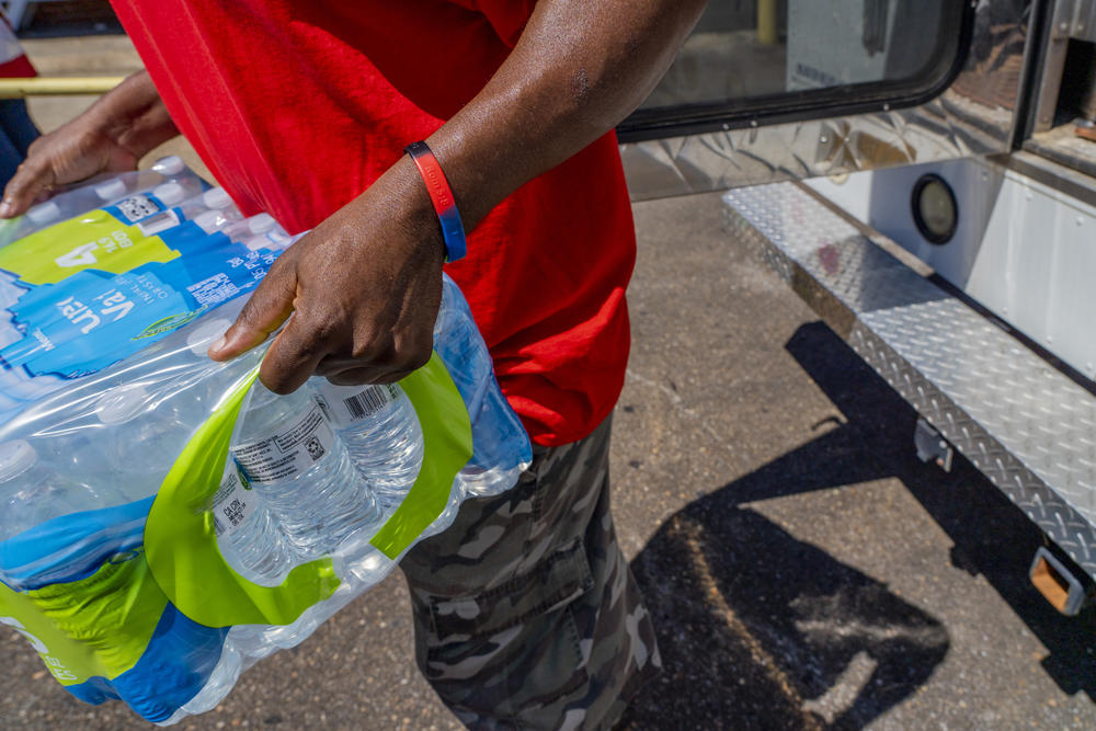 Walter Houston unloads a case of water bottles donated in Jackson, Miss., by the Salvation Army to the Mississippi Industries for the Blind.