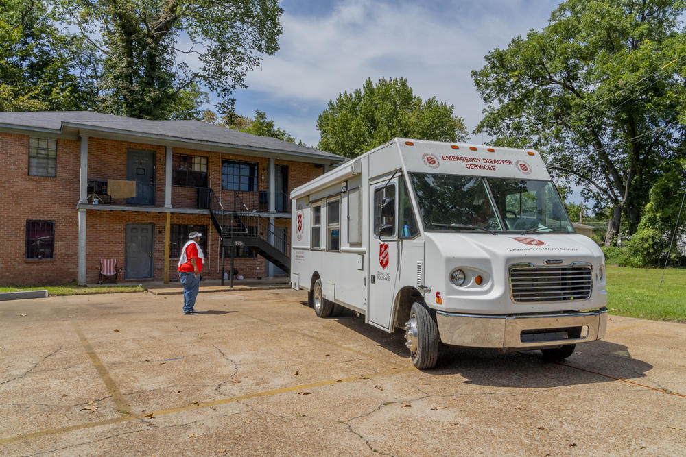 Andrew Jennings, a Salvation Army employee, signals the driver of a truck filled with water for distribution into the parking lot of an apartment complex in Jackson.