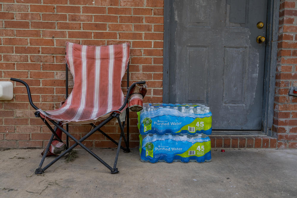 Water bottles donated by the Salvation Army are placed outside of an apartment.
