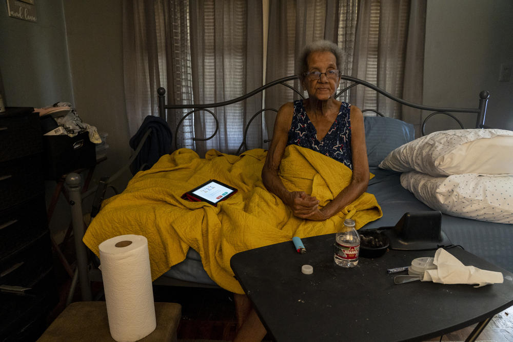 Young sits in her home after receiving a delivery of water bottles provided by the Salvation Army.
