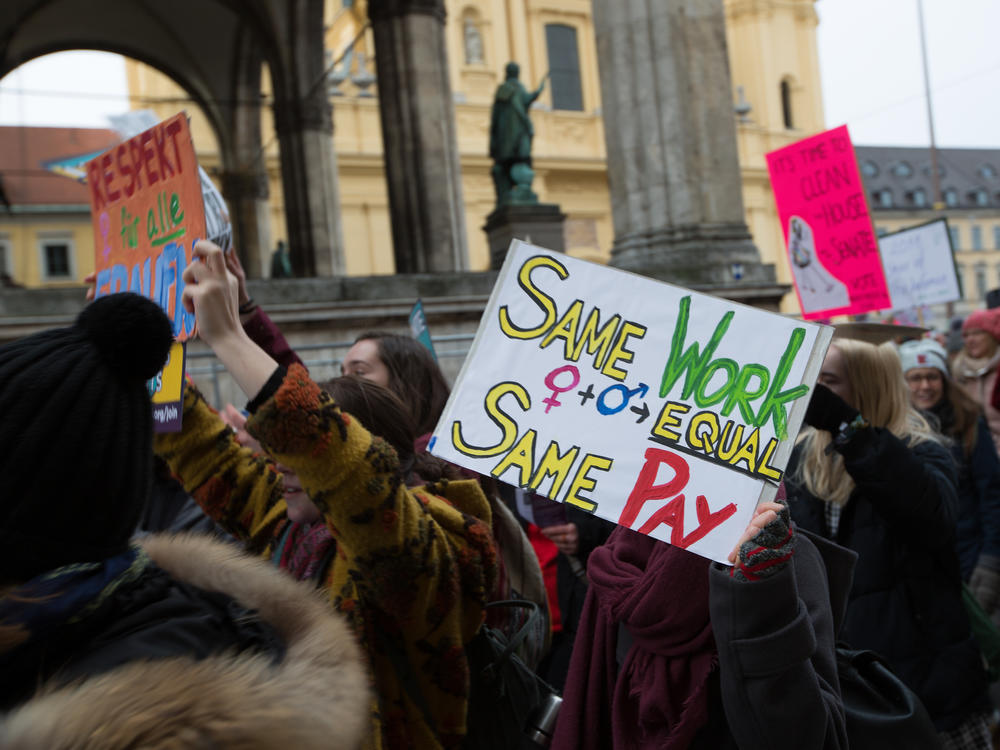 Woman hold a banner for equal pay during a 2018 march in Munich, Germany.