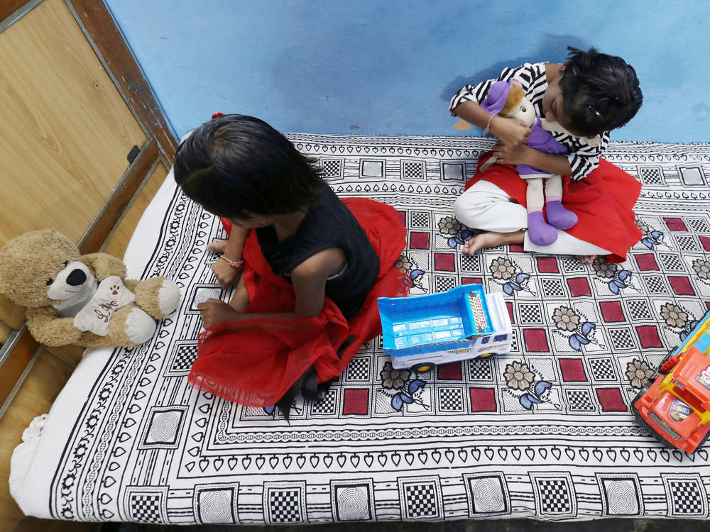 Twin sisters Tripti and Pari, who lost both their parents to COVID-19, play at a relative's home in Bhopal, India on May 11, 2021. A new study estimates that 8 million kids lost a parent or primary caregiver to a pandemic-related cause.