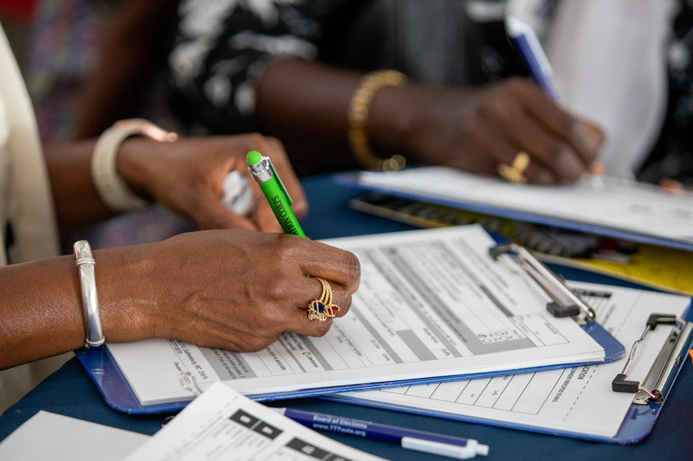 Oulimata Toure and Codou Wade-Drakeford sign up to work the polls for the midterm elections in Maryland's Montgomery County.