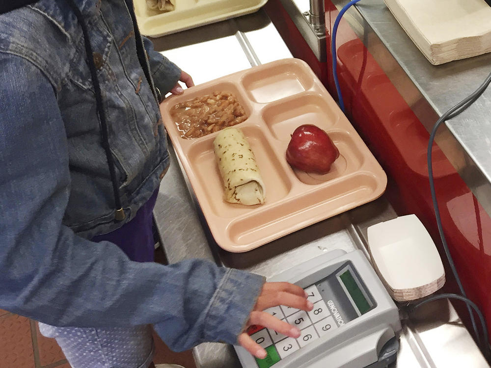 A third-grader punches in her student identification to pay for a meal at Gonzales Community School in Santa Fe, N.M. During the pandemic, schools were able to offer free school meals to all children regardless of need. Now advocates want to make that policy permanent.