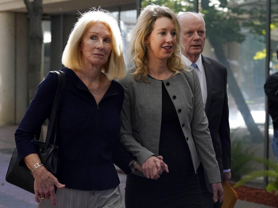 Former Theranos CEO Elizabeth Holmes, center, her mother, Noel Holmes, left, and father, Christian Holmes IV, arrive Sept. 1 at federal court in San Jose, Calif.