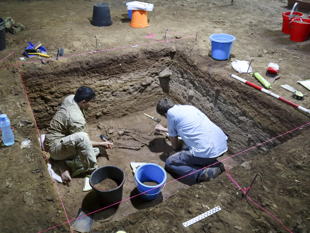 Dr. Tim Maloney and Andika Priyatno work at the site in a cave in East Kalimantan, Borneo, Indonesia, on March 2, 2020. The remains, which have been dated to 31,000 years old, mark the oldest evidence for amputation yet discovered.
