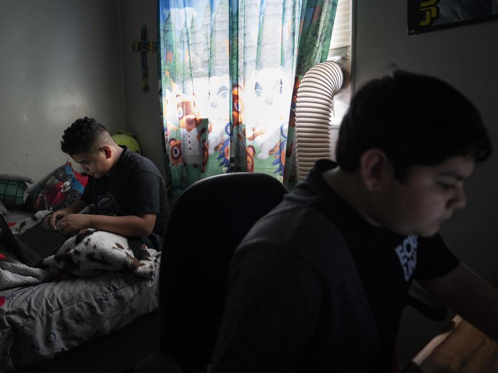 Eloyd Castro, 11, izquierda, juega videojuegos con su hermano Emmanuel Castro, 12, derecha, en su casa en Uvalde, Texas.