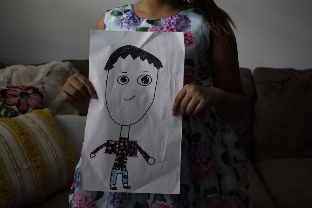 Mehle shows a drawing that she made of her friend Rojelio Torres.