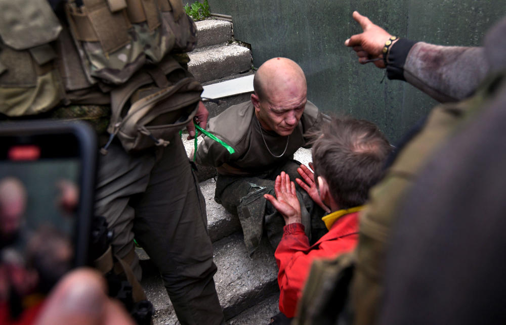 Vitalii Selevin shows his hands with his son's blood on them to a captured pro-Russia Ukrainian fighter, at a hospital in Kharkiv on May 5. Selevin's son Denis was killed by shelling.