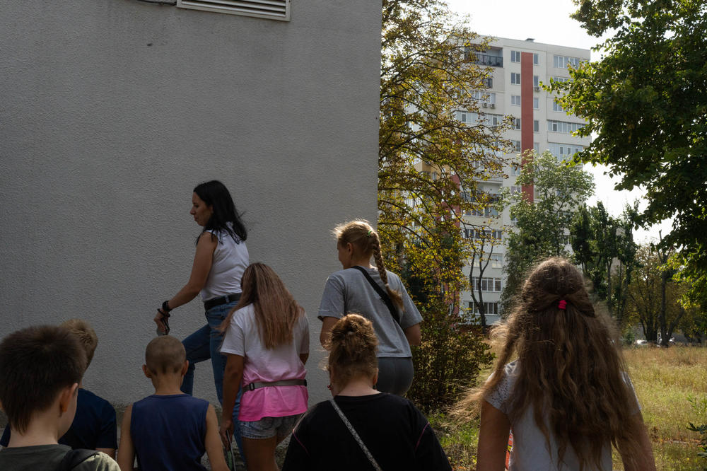A teacher leads students into a community center in Kharkiv after they participated in an outdoor training with police. These days the students rarely go outdoors while at the community center in case of shelling.