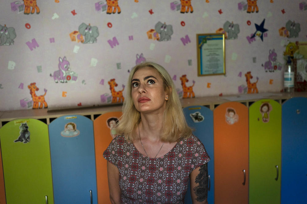 Yana Tsyhanenko, the head of a kindergarten that was recently shelled in Kharkiv, stands in front of student lockers that contain personal belongings that were left behind before the war began.