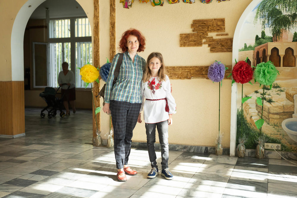 Alina Shtefan and her daughter Varya, 9, arrive on the first day of school in Dnipro.