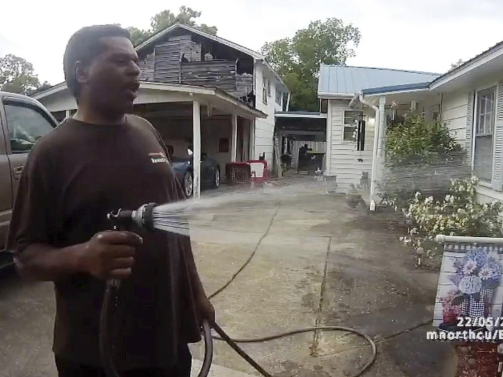 This image captured from bodycam video released by the Childersburg (Ala.) Police Department and provided by attorney Harry Daniels shows Michael Jennings, left, in custody in Childersburg, Ala., on May 22. Jennings was helping out a friend by watering flowers when officers showed up and placed him under arrest within moments.