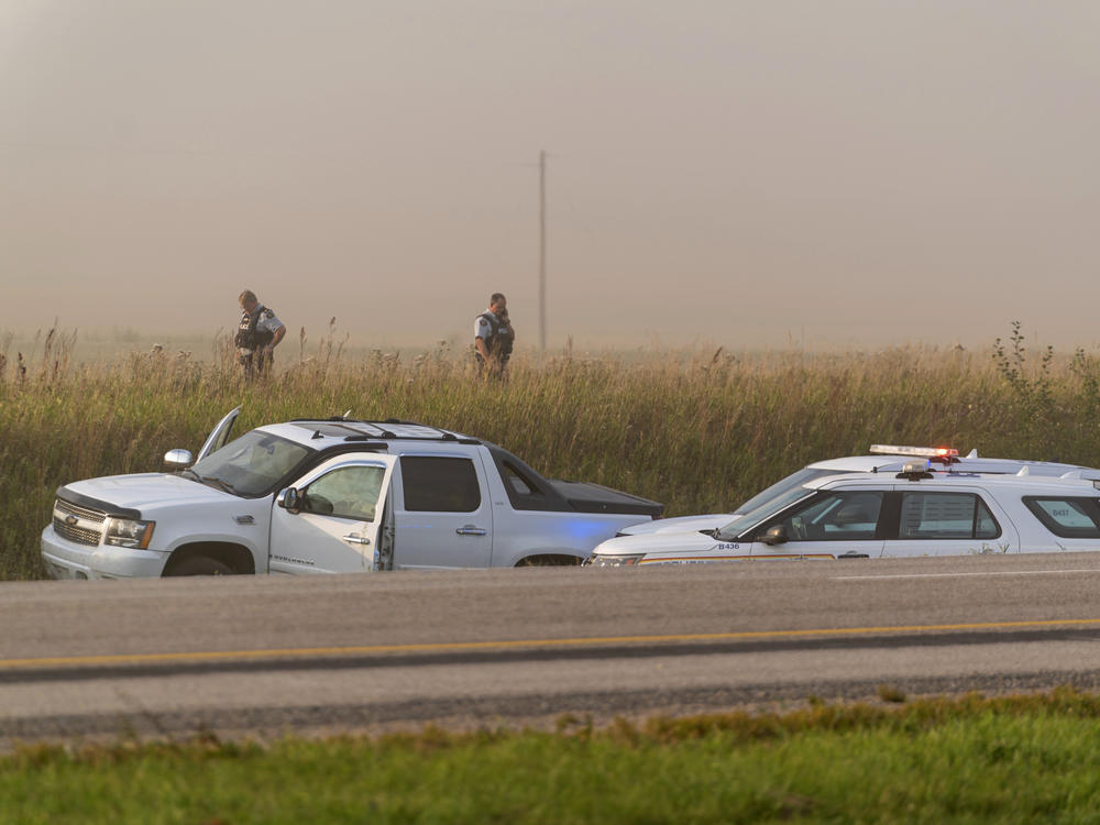 Police and investigators gather at the scene where a stabbing suspect was arrested in Rosthern, Saskatchewan, on Wednesday.