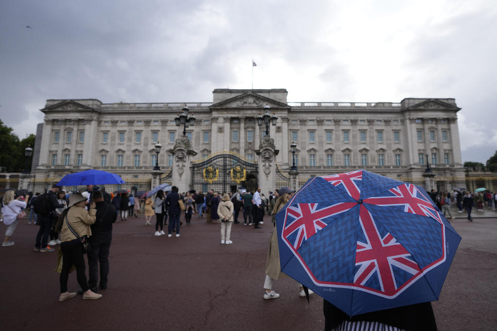 People gather outside Buckingham Palace in London on Thursday as news of the queen's health spread.