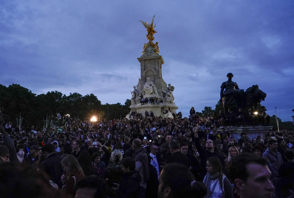 People gather in front of Buckingham Palace after the announcement of the death of Queen Elizabeth II on Thursday.