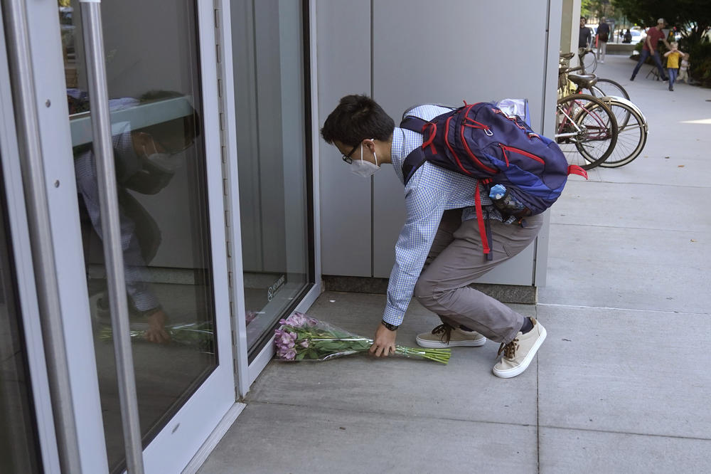 Derek Lo, of Cambridge, Mass., places flowers near an entrance to the British Consulate General in Cambridge following the passing of Queen Elizabeth II on Thursday.