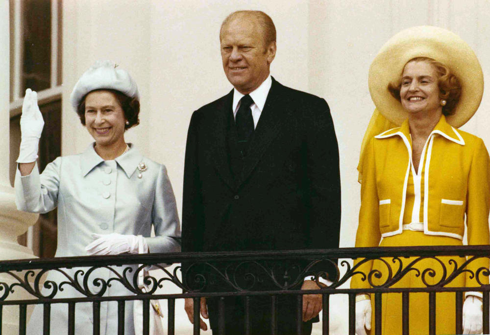 Queen Elizabeth II waves as she stands with President Gerald Ford and first lady Betty Ford on the balcony of the White House on July 7, 1976.