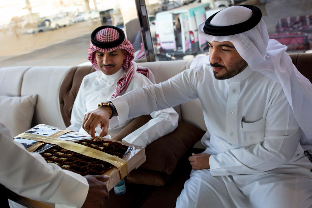 Men sample dates in the VIP tent at the Buraydah Date Festival in Buraydah on Aug. 4, 2019. Dates are considered one of the best gifts to give in Saudi Arabia and are often served covered in chocolate or stuffed with nuts or dried fruits.
