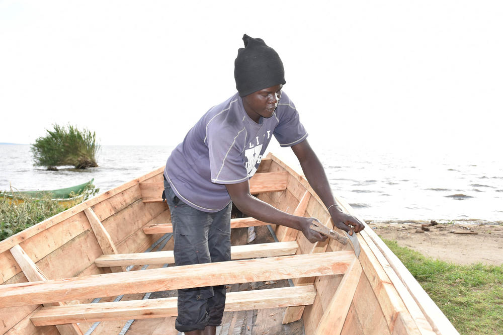 A carpenter constructs a new boat, using Ugandan hardwood, at Nduru beach. The boat is one of three being built by No Sex for Fish group, which got a grant from World Connect this year to replace the vessels they lost to catastrophic flooding.