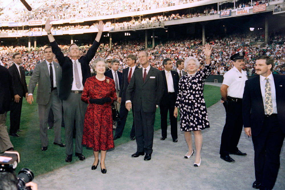 President George H.W. Bush, Queen Elizabeth II, Prince Philip, and first lady Barbara Bush wave to the crowd before the start of the Orioles vs. the Oakland Athletics baseball game at the Memorial Stadium in Baltimore on May 15, 1991.