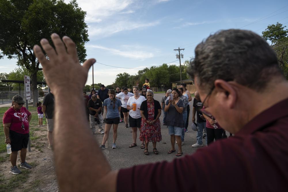 Pastor Carlos Contreras leads Uvalde residents in prayer during a walk around two local public schools. The group has been meeting every Sunday to pray for protection of each school in Uvalde.