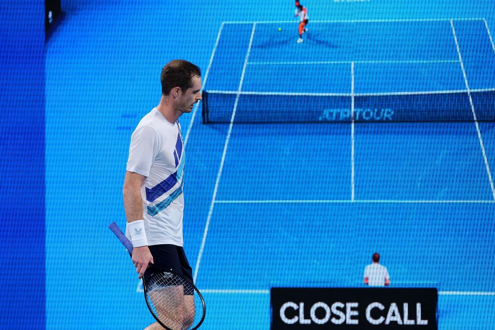 Andy Murray of Britain walks by as the result of a line call challenge Hawk-Eye review against Nikoloz Basilashvili of Georgia during their men's singles match at the Sydney Classic tennis tournament in Sydney on Jan. 12, 2022.