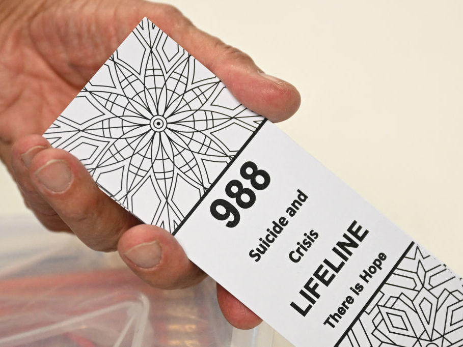 A bookmark advertising the 988 suicide and crisis lifeline emergency telephone number displayed by a volunteer with the Natrona County Suicide Prevention Task Force, in Casper, Wyoming on August 14, 2022.