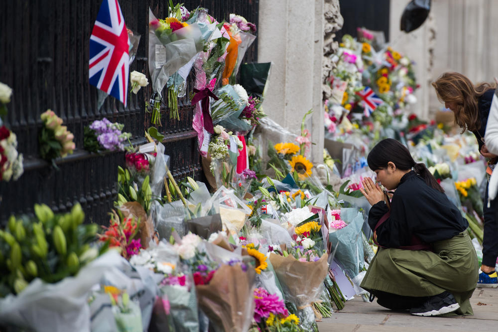 Well-wishers pay their respects outside Buckingham Palace on Friday, the first day of public mourning, following the death of Queen Elizabeth II.