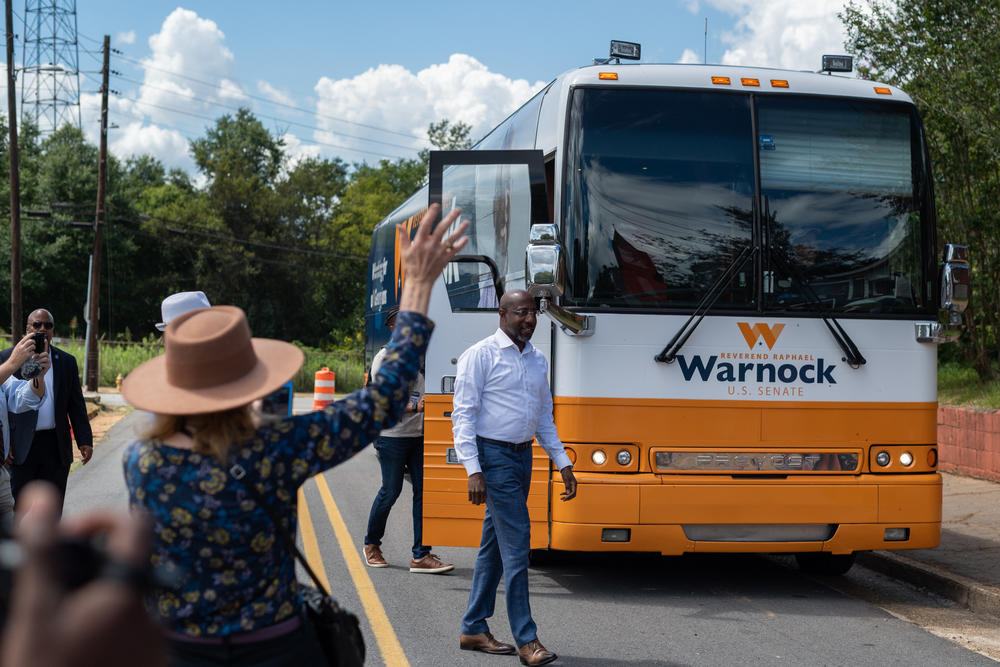 Supports cheer for U.S. Sen. Raphael Warnock outside his campaign bus in Americus, Ga.