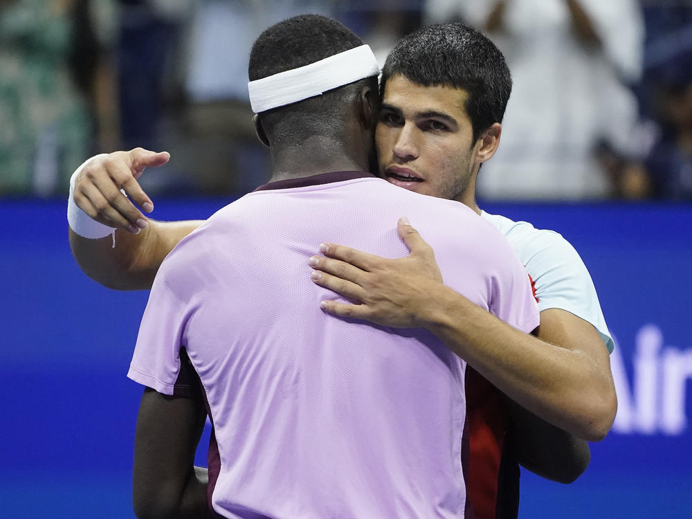 Carlos Alcaraz (right) hugs Frances Tiafoe after winning their semifinal match of the U.S. Open tennis championships on Friday in New York.