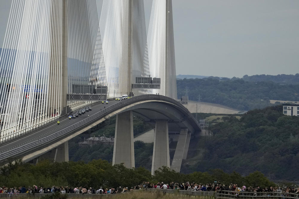 Spectators watch as the cortege with the hearse carrying the coffin of Queen Elizabeth II crosses the Queensferry Bridge.