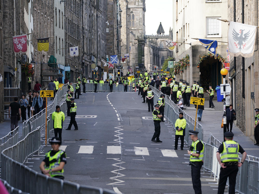 Police officers wait for Queen Elizabeth II's coffin on the Royal Mile in Edinburgh.