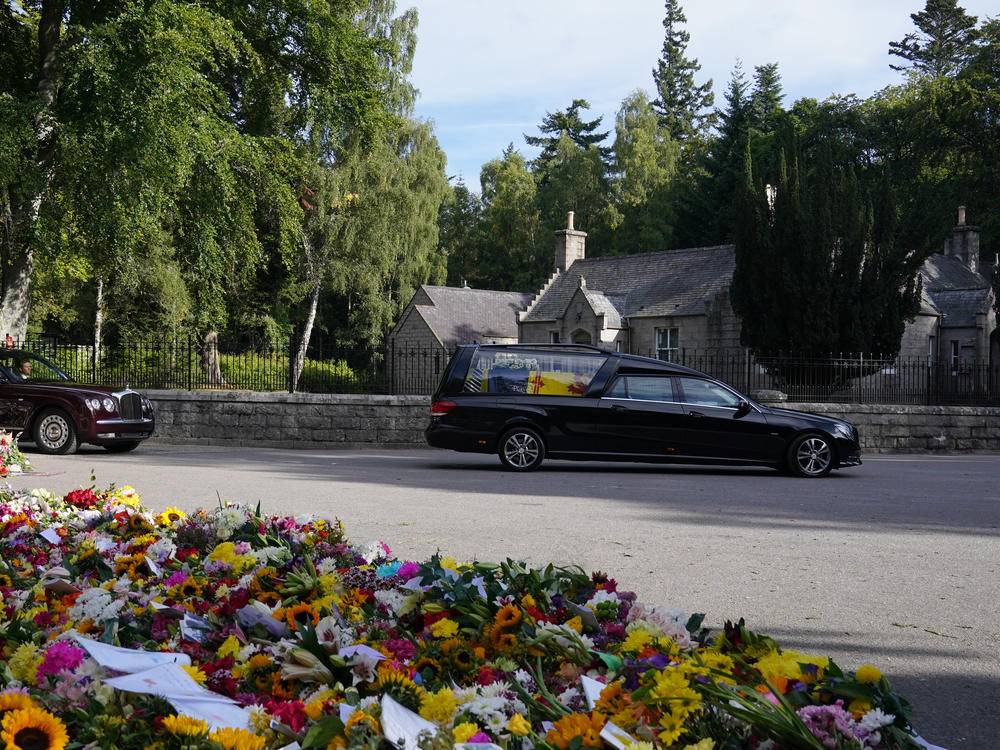 The hearse carrying the coffin of Queen Elizabeth II, draped with the Royal Standard of Scotland, leaves Balmoral as it begins its journey to Edinburgh.