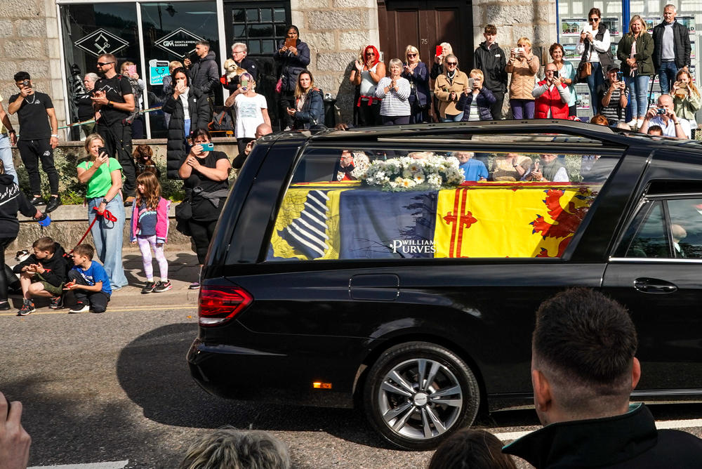 People gather in tribute as the cortege carrying the coffin of the late Queen Elizabeth II passes by in Banchory, Scotland.