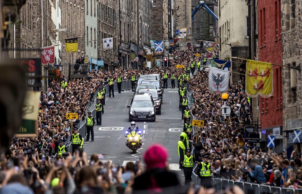 Members of the public gather along the Royal Mile to watch the hearse carrying the coffin of Queen Elizabeth II, as it is driven through Edinburgh towards the Palace of Holyroodhouse.