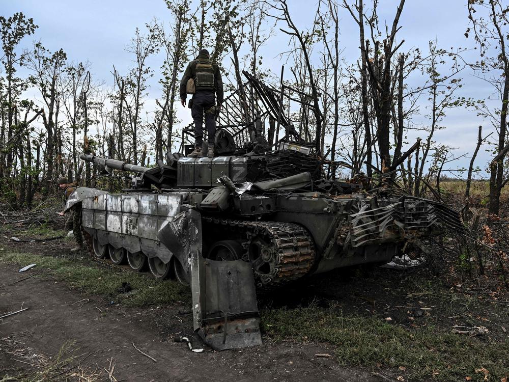 A Ukrainian soldier stands atop an abandoned Russian tank near a village on the outskirts of Izium, in the Kharkiv region, eastern Ukraine. Ukraine said its swift offensive took significant ground back from Russia.