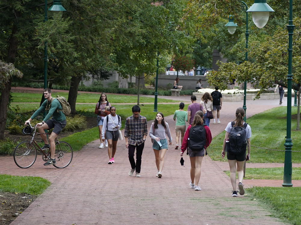 Students walk to and from classes on the Indiana University campus, Thursday, Oct. 14, 2021, in Bloomington, Ind. Indiana will tax student debt relief as income, reflecting similar policies in other U.S. states following the Biden administration's announcement of a forgiveness plan in August 2022.