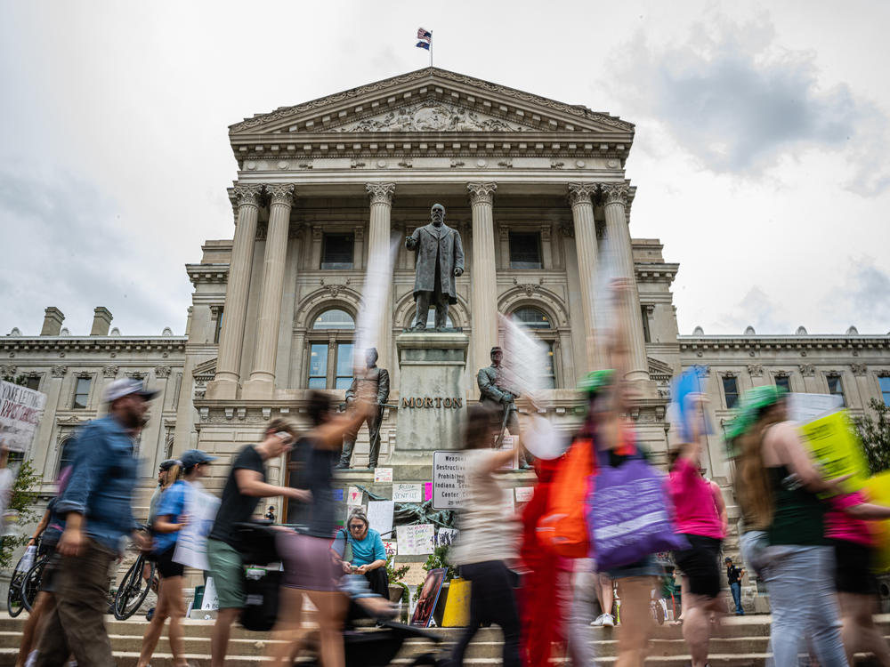 Protesters march outside the Indiana state Capitol building on July 25, 2022, in Indianapolis as activists gathered during a special session.