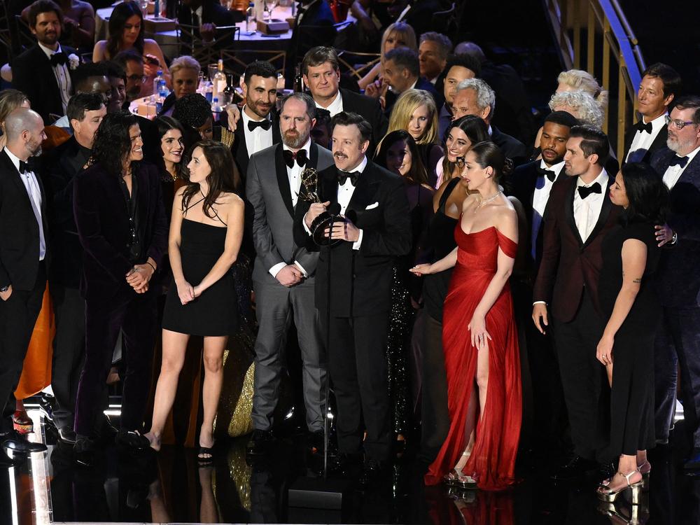 Jason Sudeikis (center) accepts the award for Outstanding Comedy Series for <em>Ted Lasso</em> along with cast and crew onstage during the 74th Emmy Awards.