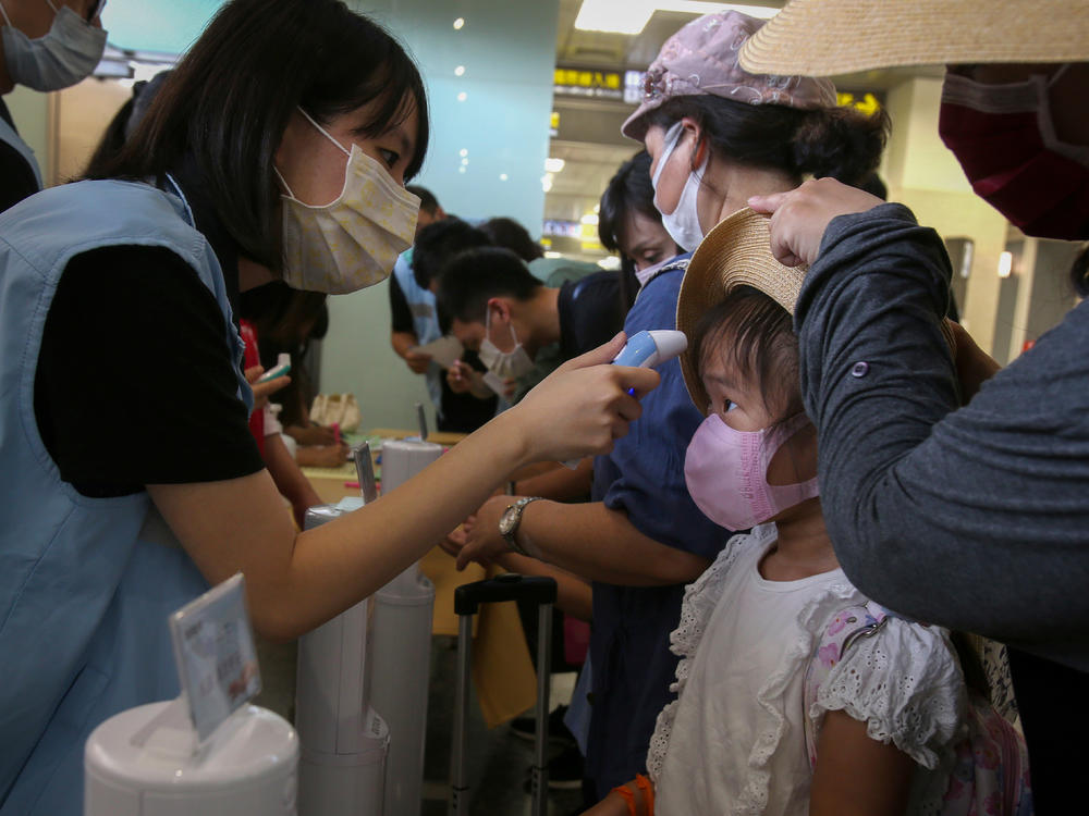 Travel rules and regulations — and national lockdowns — have varied wildly, which gave SARS-CoV-2 lots of opportunities to spread. Above: A young traveler's temperature is checked at Taipei Songshan Airport in July 2020.