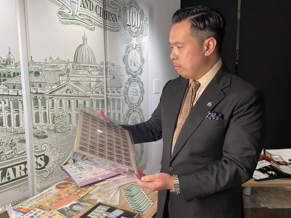 Museum owner Bryan Ong looks at old postage stamps from British Hong Kong at the private museum The Museum Victoria City in Hong Kong, on Sept. 10, 2022.
