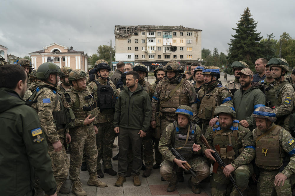 Ukrainian President Volodymyr Zelenskyy stands with soldiers after attending a national flag-raising ceremony in Izium, Ukraine, on Wednesday. Zelenskyy thanked soldiers for their efforts in retaking the area, as the Ukrainian flag was raised in front of the burned-out city hall building.