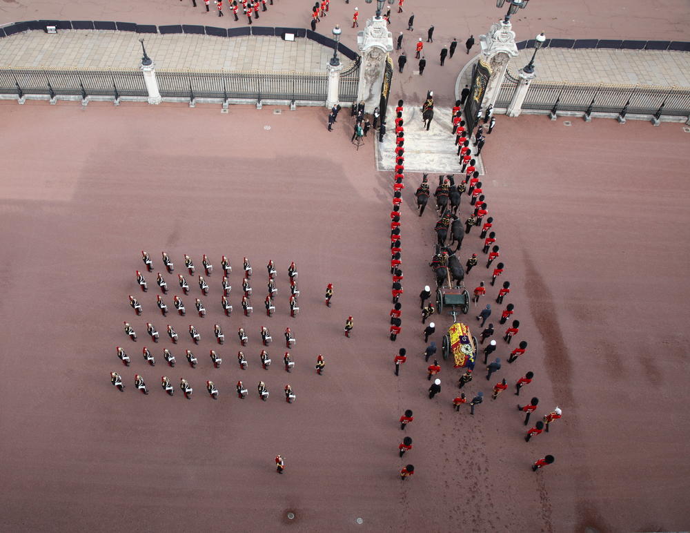 Members of the armed forces walk in formation near the coffin of Queen Elizabeth II, adorned with a Royal Standard and the Imperial State Crown, before a procession from Buckingham Palace to Westminster Hall on Wednesday.