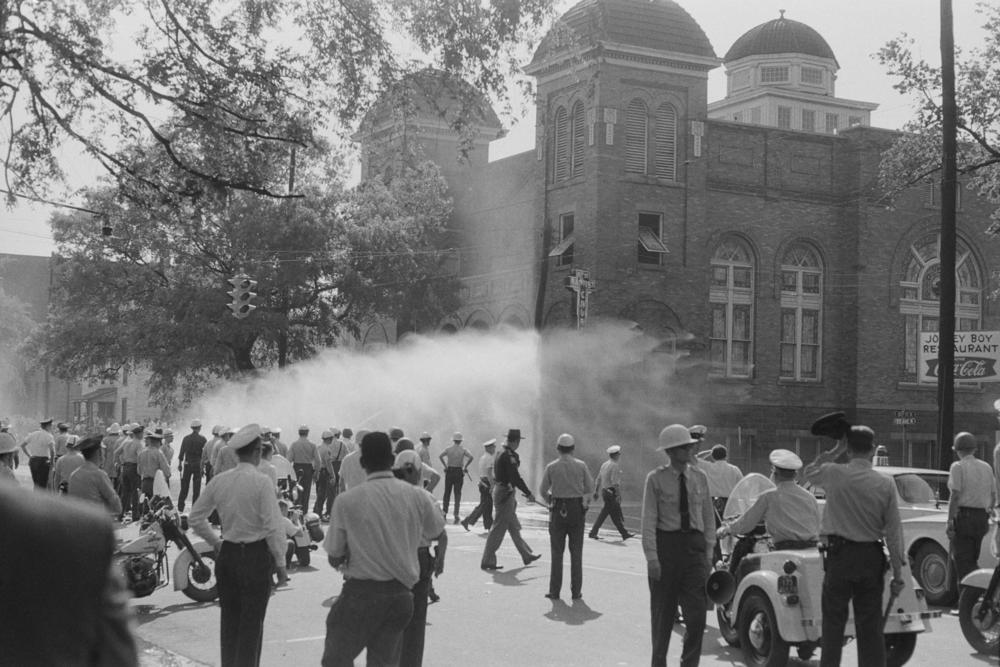 Police officers and fire fighters are called to quell unrest at the 16th Street Baptist Church, headquarters of the Birmingham Campaign in Birmingham, Ala., May 1963.