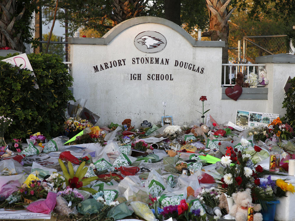 Flowers, candles and mementos sit outside one of the makeshift memorials at Marjory Stoneman Douglas High School in Parkland, Florida on February 27, 2018.