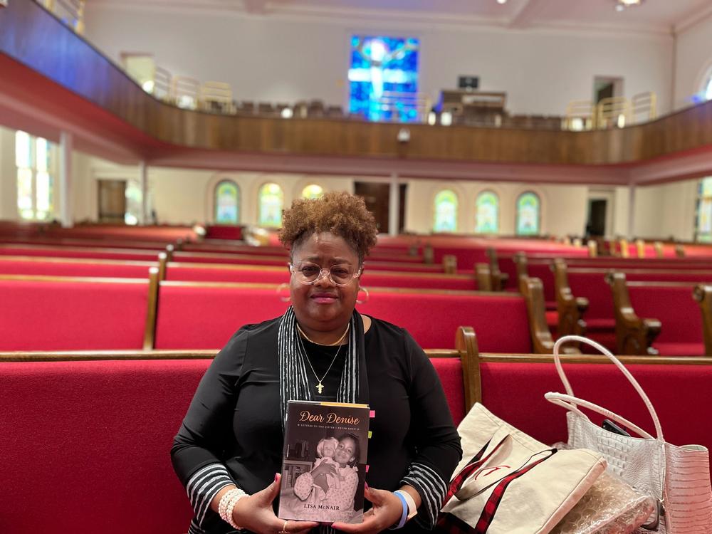 Lisa McNair holds her memoir <em>Dear Denise: Letters to the Sister I Never Knew</em>, recounting growing up in Birmingham, Ala., after her sister Denise and three other Black girls were murdered in the Ku Klux Klan bombing of 16th Street Baptist Church.