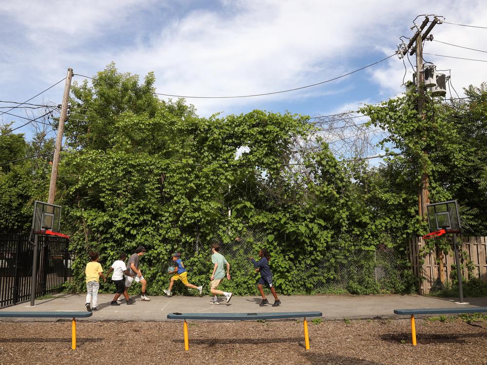 Volunteers from McQuaid Jesuit High School play basketball with the children of Cameron Community Ministries' after-school program.