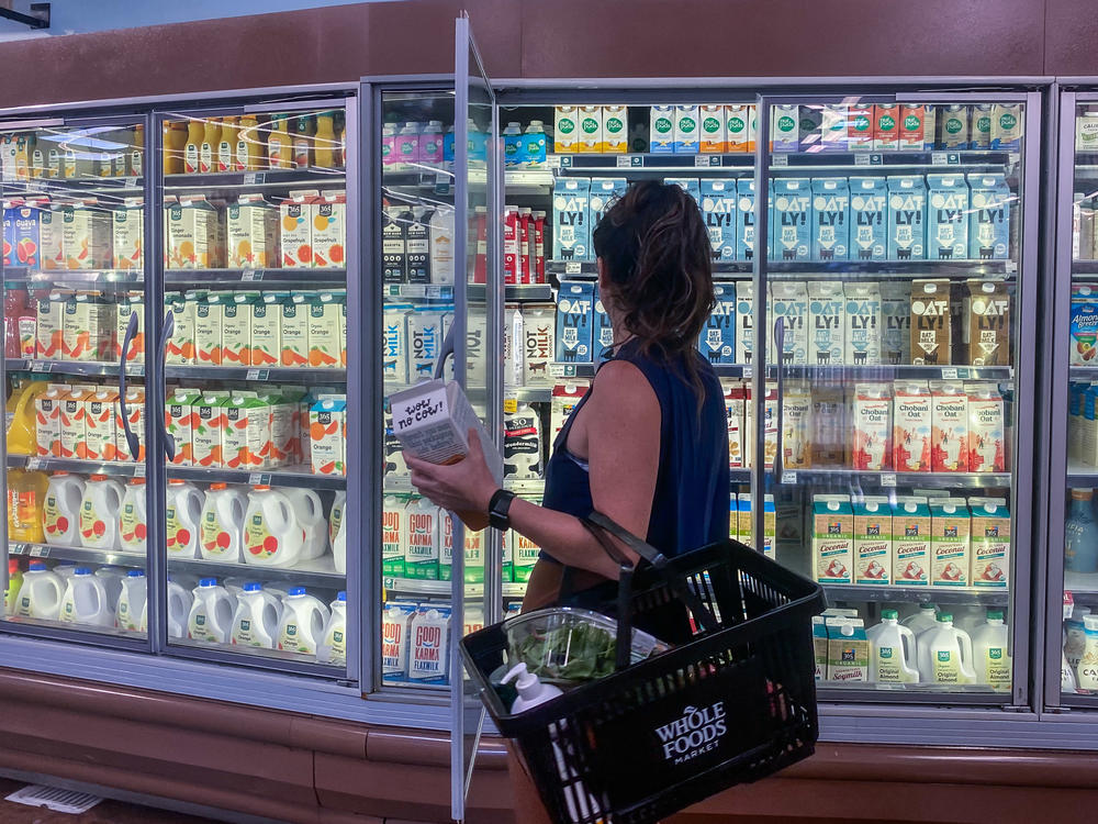 Higher fuel prices have contributed to a spike in food costs. Above, a woman shops for oat milk at a supermarket in Santa Monica, Calif., on Tuesday.